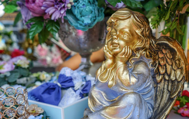 The gilded figure of an angel with wings.