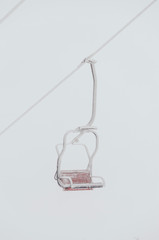 Chairs of a ski lift heading into the fog