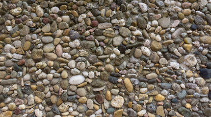 Background / Texture of small natural stones / gravel in cement wall