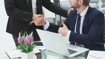 handshake Manager and client, near the table in the office.photo with copy space