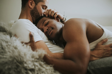 Gay couple cuddling in bed - Powered by Adobe