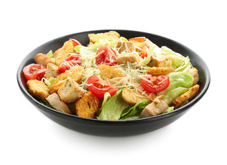 Plate with tasty Caesar salad on white background