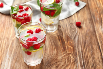 Glasses of fresh raspberry mojito on wooden table