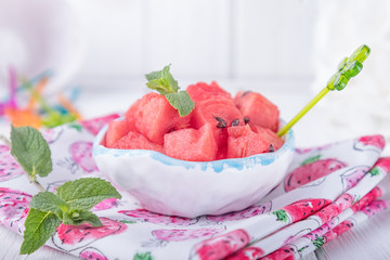 Ceramic bowl with watermelon cubes on a white wbackground. Close-up, free space