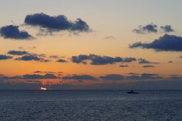 Naklejka na ściany i meble Beautiful sunset with fishing boat