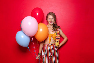Fototapeta na wymiar Beautiful young woman with balloons on color background