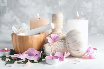 Spa composition with hydrangea flowers and burning candles on light table