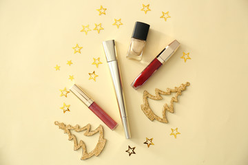 Set of cosmetics with Christmas decorations on color background