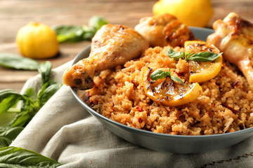 Tasty boiled rice with chicken drumsticks in bowl on table