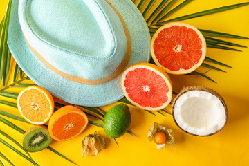 Various delicious exotic fruits with hat on color background