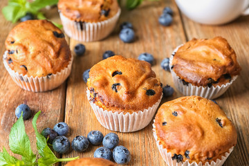 Tasty blueberry muffins on wooden table