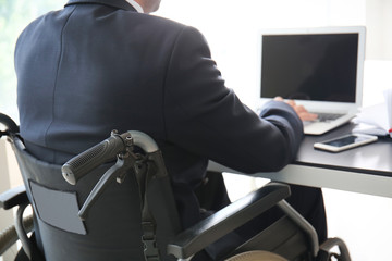 Businessman in wheelchair working in office