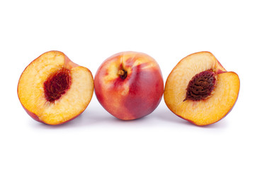 Naklejka na ściany i meble One peach and two halves of a peach with a stone on a white background isolated close up
