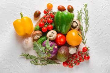 Composition with fresh vegetables on white textured background