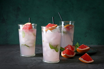 Glasses of refreshing grapefruit lemonade on table