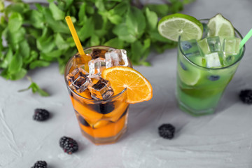 Glasses of refreshing summer cocktail with fruits and berries on table