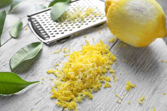 Peeled ripe lemon with zest on wooden background