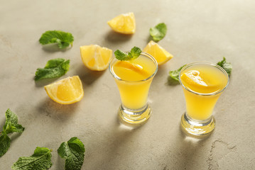 Glasses of fresh lemon cocktail on grey background