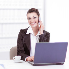 Executive business woman talking on mobile phone in office