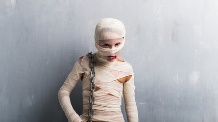 Boy in mummy costume with chains for halloween holidays