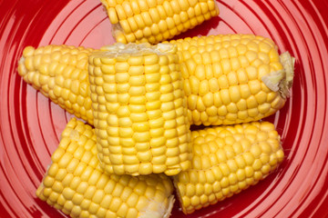 Maíz en trozos sobre plato rojo. Vista superior y de cerca