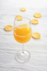 Glass of fresh lemon juice on white wooden table