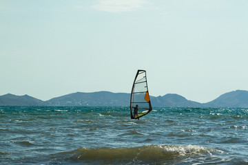 sail windsurfing in the sea against the backdrop of the mountain range