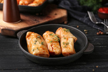 Pan with stuffed cabbage leaves on wooden table