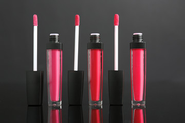 Different liquid lipsticks on grey background