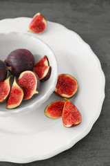 Bowl with fresh ripe figs on grey table