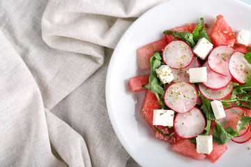 Plate with delicious watermelon salad on table, top view