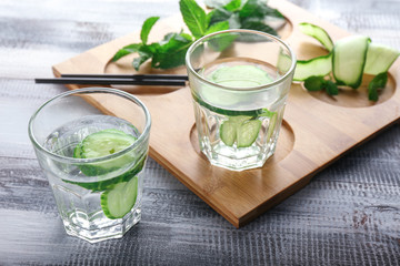 Glasses of cucumber infused water on wooden table