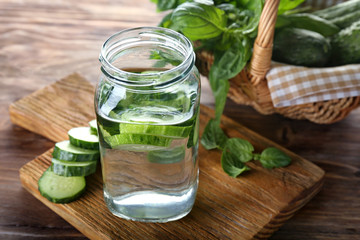 Jar of cucumber infused water on wooden table