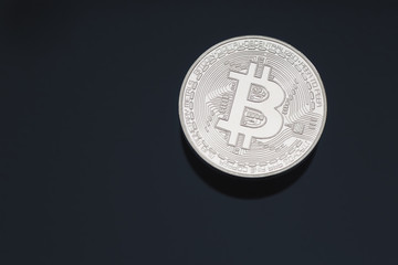 Bitcoin cryptocurrency coin token close up cleaned silver macro with black background and copy space.