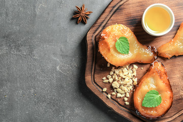 Halves of tasty baked pears with honey on wooden board