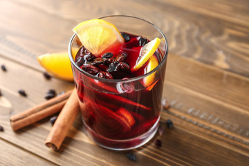 Glass of delicious mulled wine on wooden table