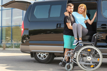 Fototapeta na wymiar Man helping handicapped woman to sit in wheelchair
