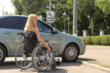 Fototapeta na wymiar Woman in wheelchair next to her car