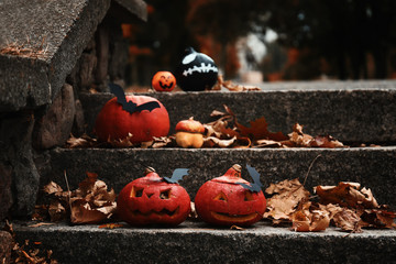 Halloween pumpkins with creative decorations on stairs outdoors