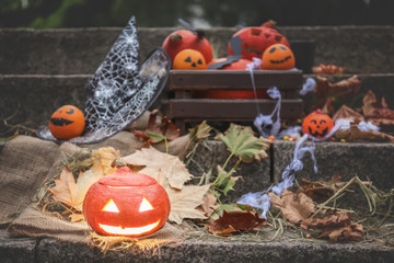 Halloween pumpkin with creative decorations on stairs outdoors