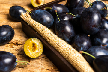 Plums on rustic wooden table