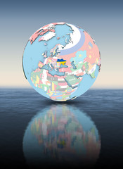 Ukraine on globe with flags above water surface