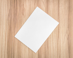 White paper sheet on wooden background. Template of A4 document and blank space for text.