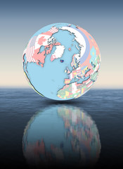 Iceland on globe with flags above water surface