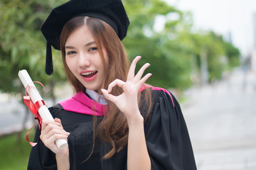 happy smiling graduated woman university student points ok sign; portrait of smiling woman student...
