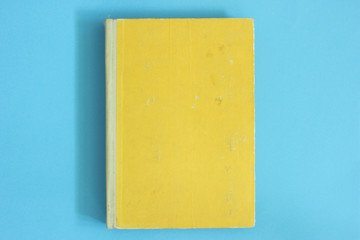 Old yellow book  on blue desk .Back to school background 