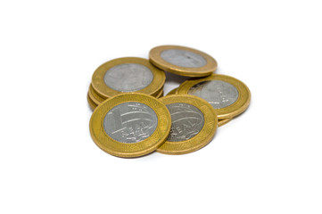 pile of Brazilian currency coins, in the present value of 1 one real, isolated on white background