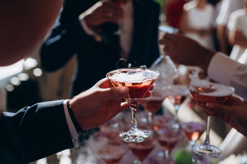  Hands holding the glasses of champagne and wine making a toast.
