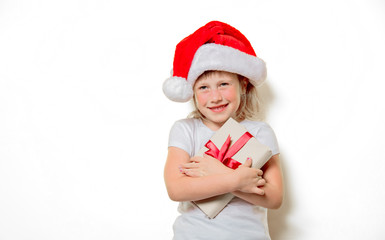 Portrait of an emotional toddler girl in Christmas hat with gift box on white background