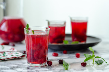 Fresh cranberry drink on marble background.